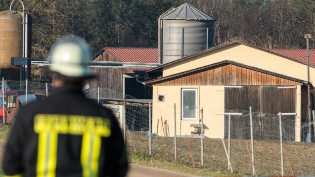 Ein Feuerwehrmann steht am 7.12.2015 vor dem Geflügelhof in Roding (Bayern). Auf dem Hof haben Experten Hinweise auf Geflügelpest gefunden. Knapp 13 000 Tiere mussten notgeschlachtet werden. Foto: Armin Weigel/dpa