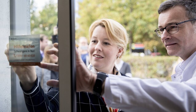 Bundesfamilienministerin Franziska Giffey (SPD) bringt in der Berliner Pfauen-Apotheke am Eingang einen Aufkleber des Hilfetelefons „Schwangere in Not“ an. (Foto: photothek / imago)