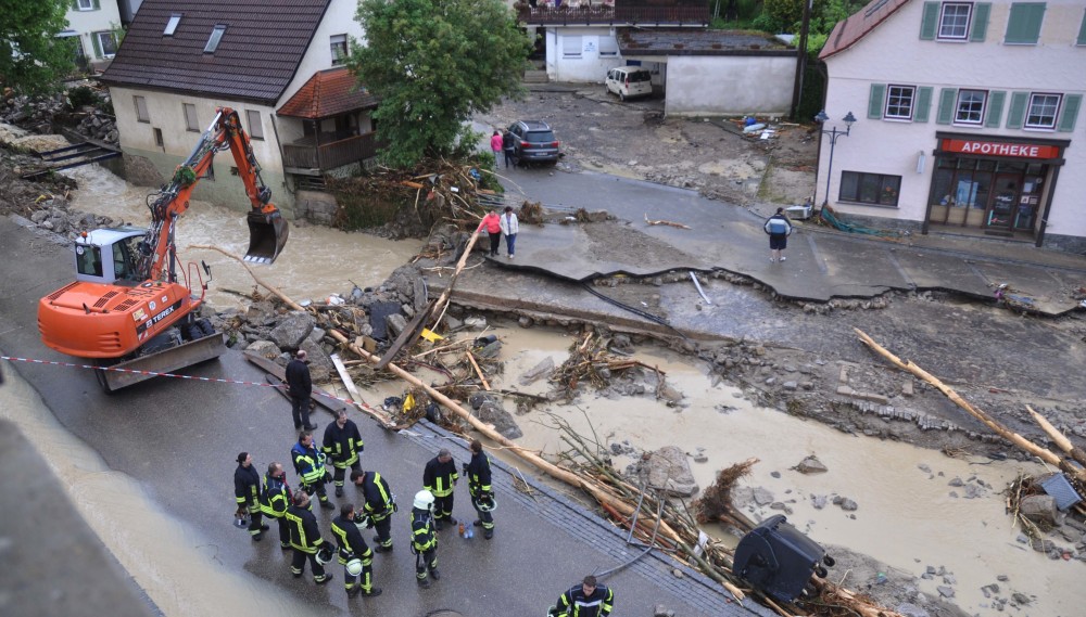 Ein Bagger räumt am 30.05.2016 in Braunsbach die mit Schutt bedeckte und teilweise eingestürzte Straße vor der Apotheke. (Foto: dpa / picture alliance)