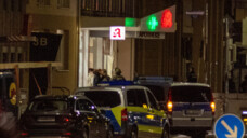 Die Polizei Karlsruhe führt am Freitagabend nach einer Geiselnahme den mutmaßlichen Täter (weiße Jacke) aus der Apotheke. Er sitzt in Untersuchungshaft. (Foto: IMAGO / Nicolaj Zownir)