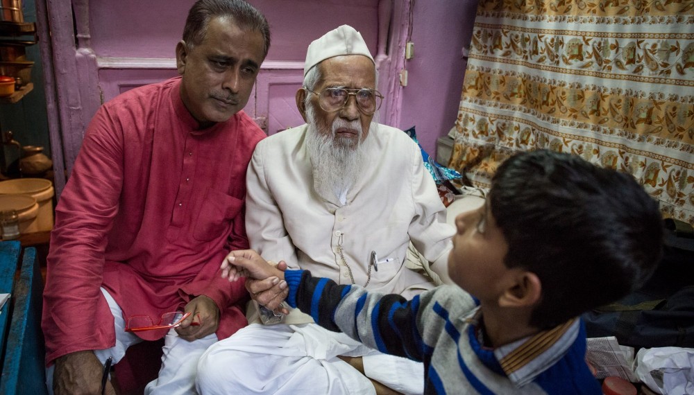Syed
Mohammad Sharfuddin Quadri liest den Puls
eines jungen Patienten. Neben der Betrachtung des Urins diagnostizierte Quadri Krankheiten und Beschwerden auch über Unregelmäßigkeiten im Herzschlag seiner Besucher.